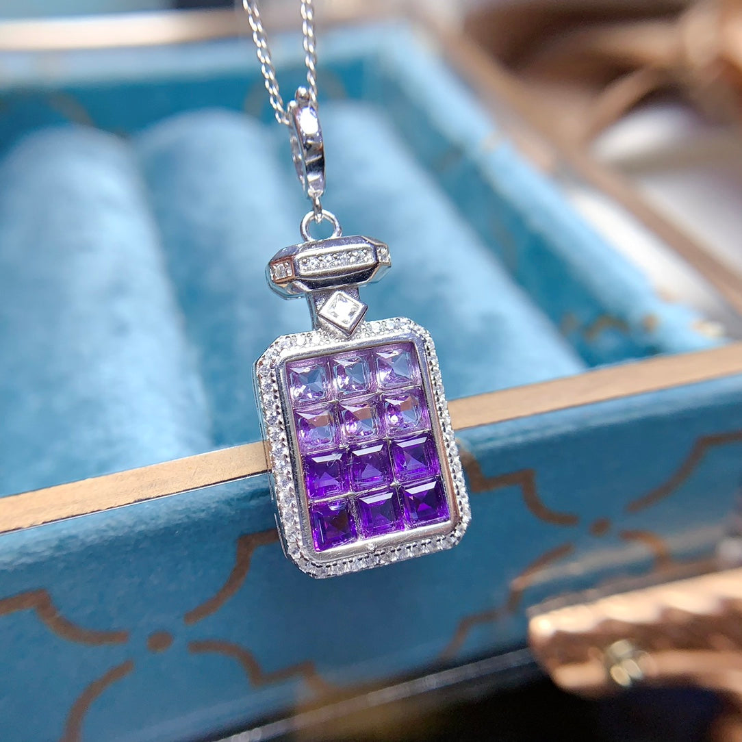 A pendant made of natural gemstones, designed to open, available in four different color options.