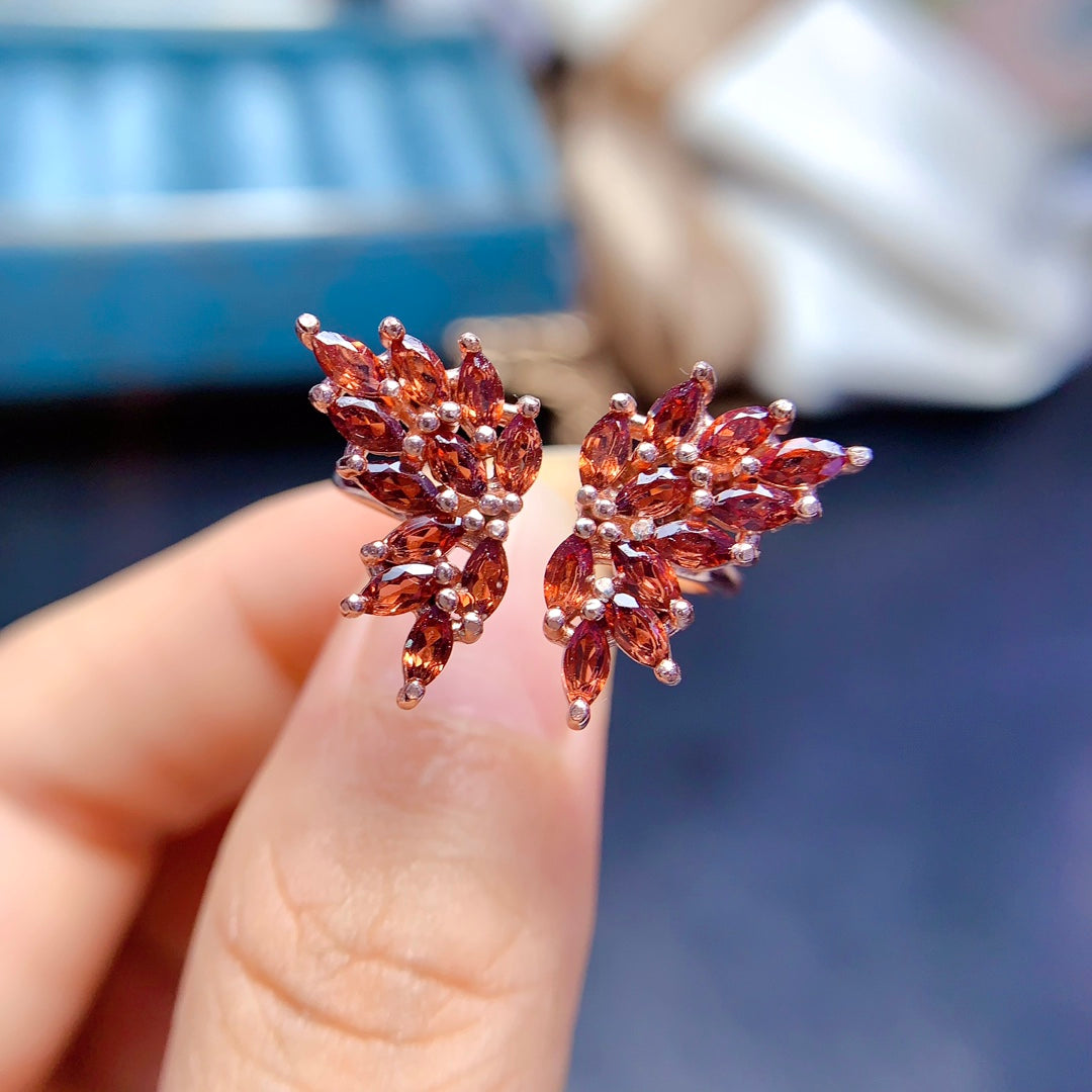 A ring made with multiple gemstones in a butterfly design, each handcrafted with 22 stones. Available in various colors, featuring natural garnet, topaz, tanzanite, and diopside.