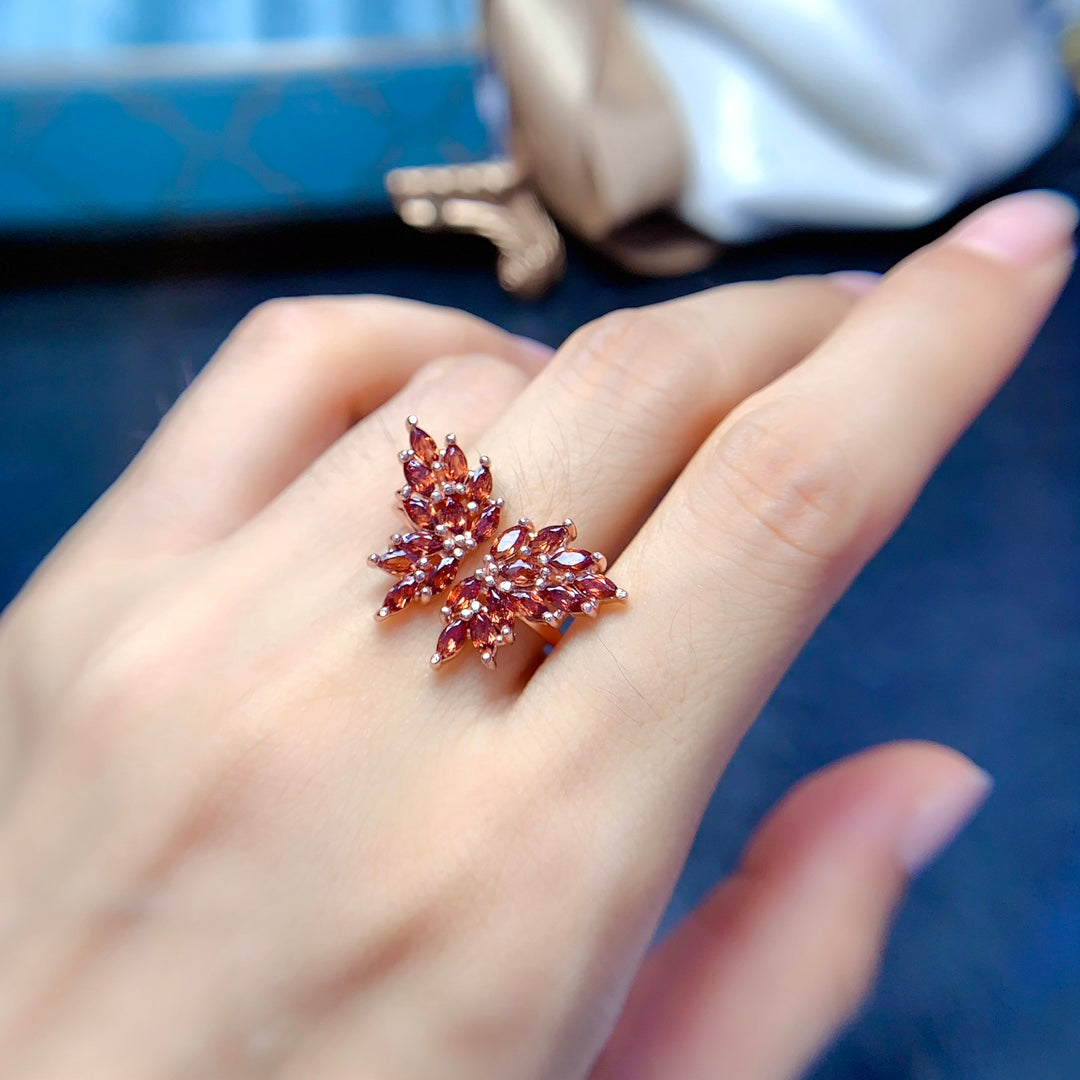 A ring made with multiple gemstones in a butterfly design, each handcrafted with 22 stones. Available in various colors, featuring natural garnet, topaz, tanzanite, and diopside.