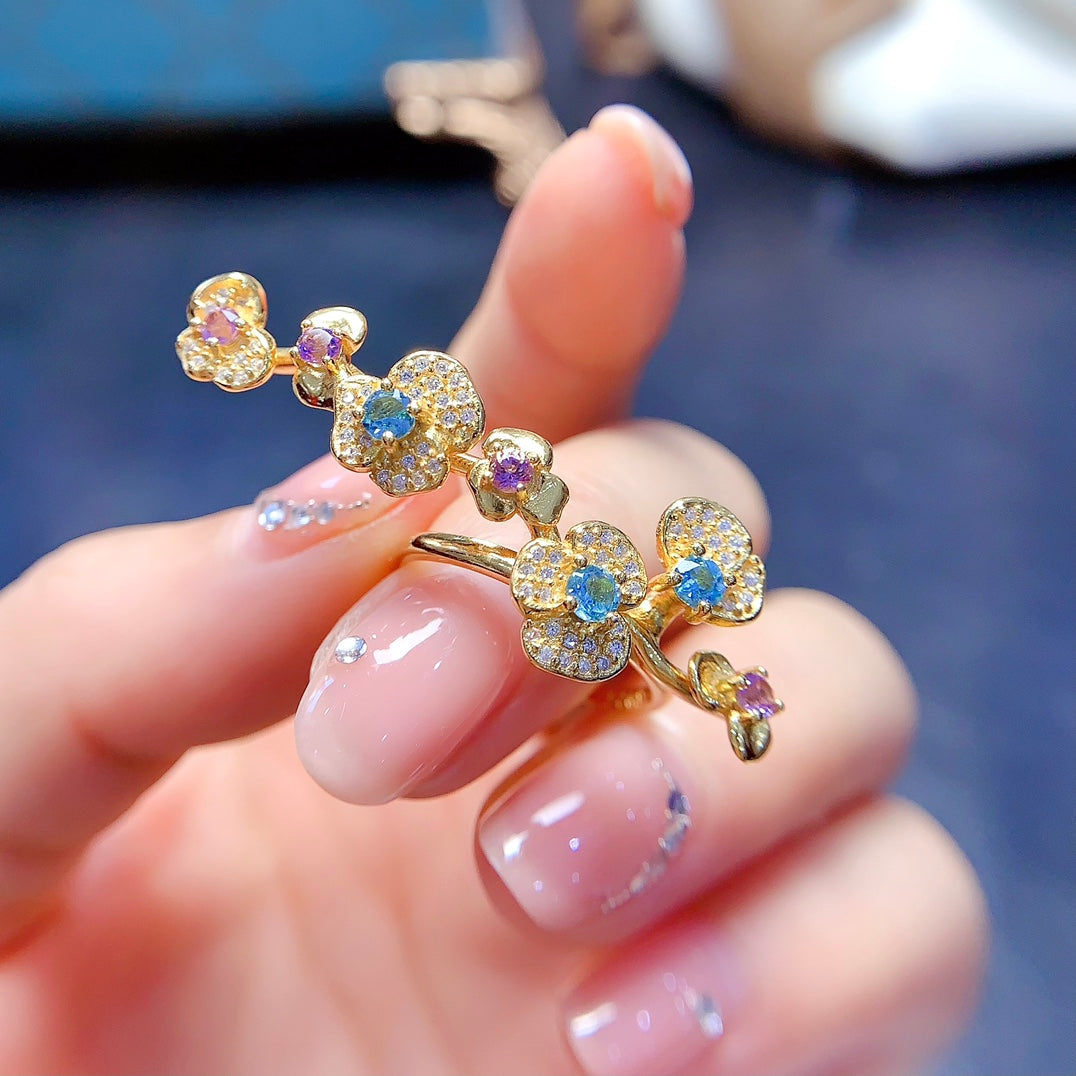 A ring crafted from natural crystal and topaz, this piece exudes a unique, floral-inspired design that resembles a delicate flower blooming on your hand.