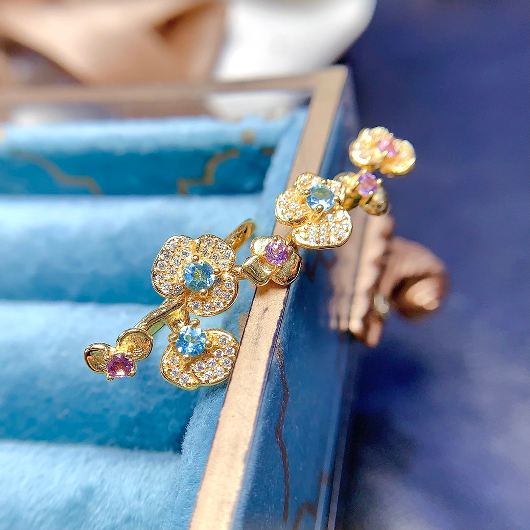 A ring crafted from natural crystal and topaz, this piece exudes a unique, floral-inspired design that resembles a delicate flower blooming on your hand.